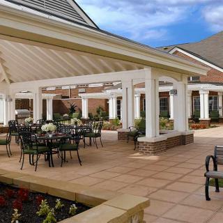 A spacious outdoor patio area with a pergola and seating arrangements.