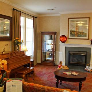A cozy living room featuring a piano, fireplace, and elegant decor.