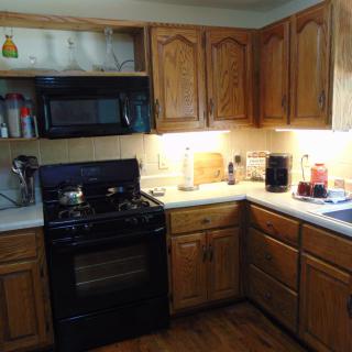 A cozy kitchen with wooden cabinets and various appliances.