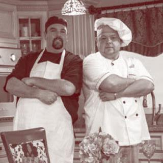 Two chefs posing confidently in a kitchen.