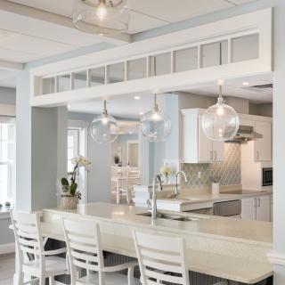 A modern kitchen with a spacious layout, featuring a large countertop and stylish pendant lighting.