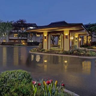 Elegant building entrance illuminated at night with landscaped gardens.
