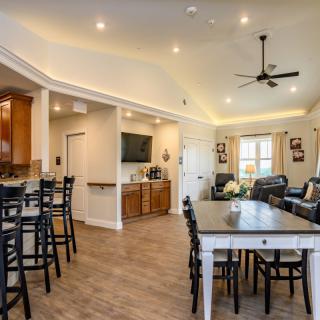 A modern open-concept living space featuring a kitchen, dining area, and living room with wood flooring and recessed lighting.