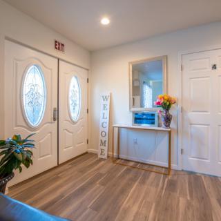 A welcoming entryway featuring a large mirror, fresh flowers, and a stylish console table.