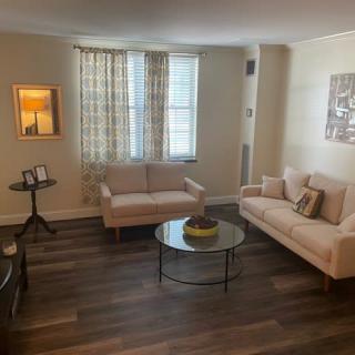 A cozy living room with a stylish design, featuring sofas and a glass coffee table.