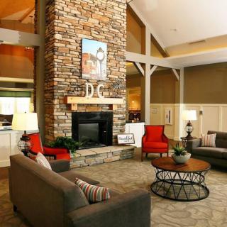 A cozy living room with a rustic stone fireplace and comfortable seating.