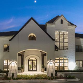 A well-lit house exterior at dusk with a modern architectural design.