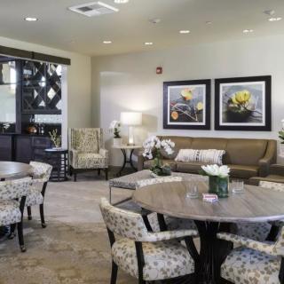A cozy and elegantly designed living room featuring comfortable seating, decorative artwork, and stylish furniture arrangement.