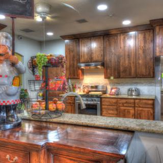 A cozy and well-equipped kitchen featuring wooden cabinets and a granite countertop, perfect for culinary adventures.