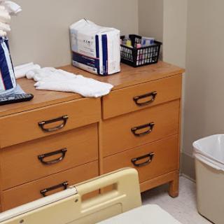 A glimpse of a hospital patient room featuring cabinets and medical supplies.