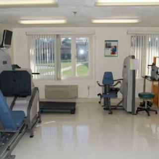 A clean and well-lit gym with various exercise machines.