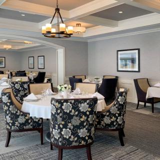 An elegantly decorated dining room with floral-patterned chairs and a well-set table.