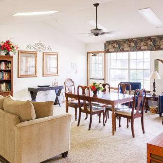 A cozy living room and dining area with elegant furniture and large windows providing ample natural light.