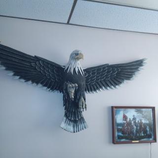 A decorative wall piece of a soaring eagle, accompanied by a framed picture.