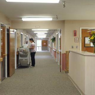 A hospital corridor with a nurse attending to a cart.