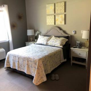 A cozy bedroom with a neatly made bed, nightstands, and decorative elements.