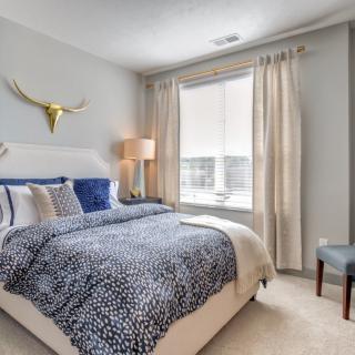 A modern bedroom with stylish decor and a large window.