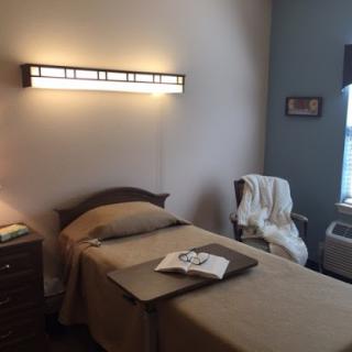 A serene bedroom setting with a single bed, soft lighting, and a cozy atmosphere.