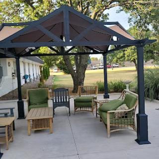 A cozy outdoor seating area under a gazebo, perfect for relaxation and enjoying nature.