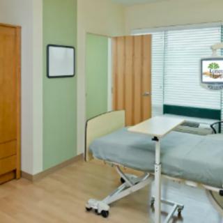A clean and modern hospital room with a bed and medical equipment.