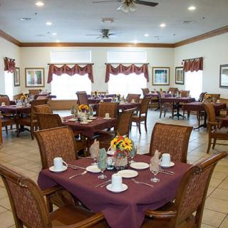 A cozy dining room with neatly arranged tables and chairs, adorned with elegant decor.
