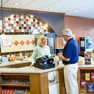 A customer and a staff member interacting at the counter of a cafe.