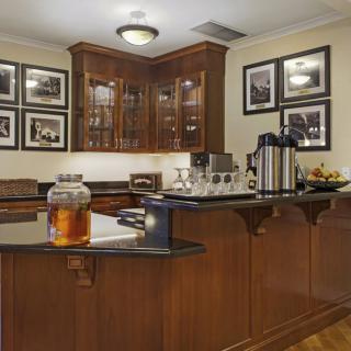 A well-organized kitchen area with wooden cabinets and a coffee station.