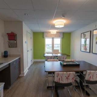 A modern kitchen and dining area with a vibrant green accent wall.