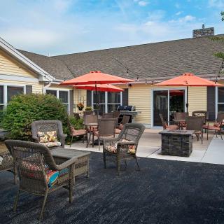 A cozy outdoor patio area with wicker chairs and bright orange umbrellas.