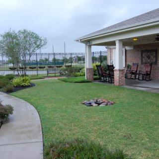 A well-maintained garden with a patio and pathway leading to a house.