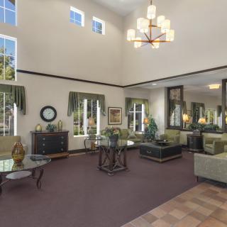 Spacious living room with high ceilings, elegant decor, and a chandelier.