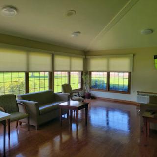 A cozy living room featuring comfortable seating and large windows that let in plenty of natural light.