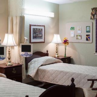 A cozy room with twin beds and warm lighting, decorated with lamps and artwork.