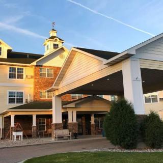 A large residential building, possibly a retirement home, illuminated by the warm light of sunset.