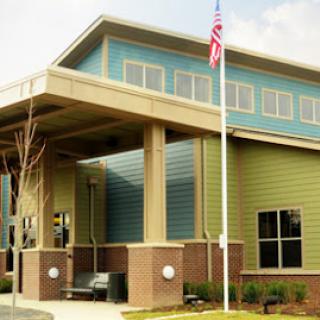 A modern building with a flagpole and large windows, showcasing contemporary architecture.