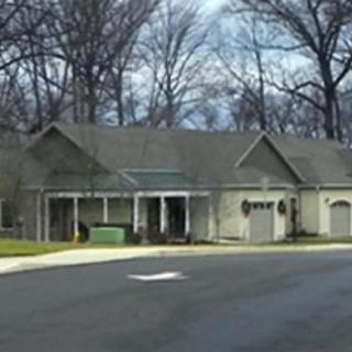 A suburban house with a driveway and surrounding trees.