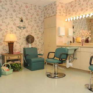 A vintage hair salon with floral wallpaper and retro styling chairs.