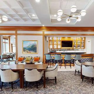 A contemporary dining and bar area with stylish furniture, modern lighting, and decorative artwork.