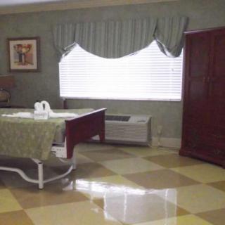 A hospital room with a bed, window, and furnishings.