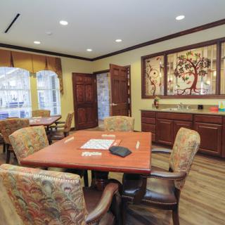 A cozy dining area with a wooden table, upholstered chairs, and decorative artwork on the walls.