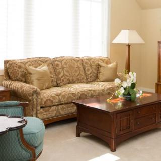 A cozy living room with a patterned sofa, wooden coffee table, and soft lighting.