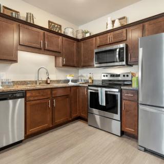 A modern kitchen featuring sleek stainless steel appliances and warm wooden cabinetry.
