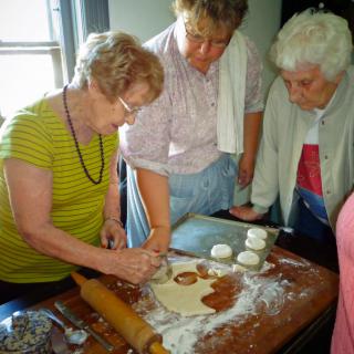 A group of people engaged in a baking activity, working together to prepare dough.