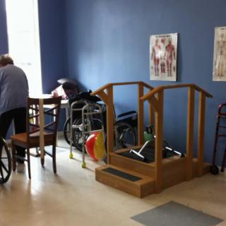 A rehabilitation room equipped with exercise equipment and therapy tools.
