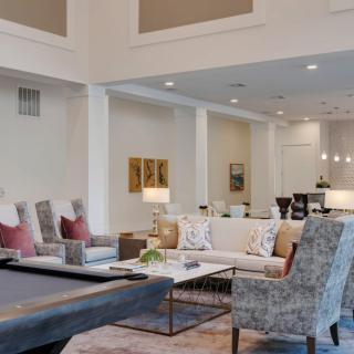 A spacious and elegantly designed living room featuring modern decor with neutral colors and comfortable seating.