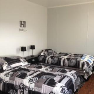 A neatly arranged bedroom with twin beds and modern decor.