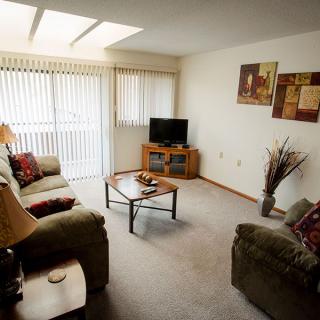 A cozy living room with sofas, a coffee table, and a television.
