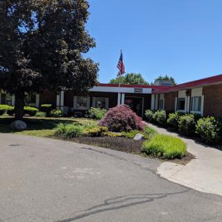 A well-maintained building with lush landscaping and a flag flying in the front.