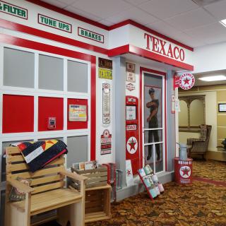 A vintage Texaco gas station-themed display indoors, featuring retro decorations and signage.