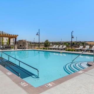 An inviting outdoor swimming pool surrounded by deck chairs under a clear blue sky.
